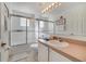 Bright bathroom featuring a shower-tub combination with sliding glass doors and a clean, well-lit vanity area at 1001 Park Ridge Cir, Kissimmee, FL 34746