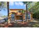 Charming two-story home with an orange facade and tropical landscaping, including palm trees at 1001 Park Ridge Cir, Kissimmee, FL 34746