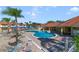 Community pool area with ample lounge chairs, palm trees, and seating under blue umbrellas at 1001 Park Ridge Cir, Kissimmee, FL 34746
