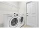 Bright laundry room with white washer and dryer and tile flooring at 10081 Cobalt Bay Rd, Orlando, FL 32827