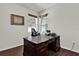 Home office with dark wood flooring, two windows, and classic desk at 10081 Cobalt Bay Rd, Orlando, FL 32827