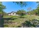 Spacious backyard with green lawn, shade trees, and partial fencing on a sunny day at 1021 Mare Bello Dr, Winter Park, FL 32792