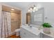 Well-lit bathroom with updated vanity, mirror, and tiled shower at 1021 Mare Bello Dr, Winter Park, FL 32792