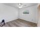 Clean bedroom with wood-look floors, ceiling fan, a bright window, and freshly painted white walls at 1021 Mare Bello Dr, Winter Park, FL 32792