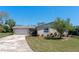 Charming single-story home with a well-maintained lawn, flowering shrubs, and an attached garage at 1021 Mare Bello Dr, Winter Park, FL 32792