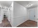 Hallway with wood laminate flooring leading to a white front door and multiple rooms at 1021 Mare Bello Dr, Winter Park, FL 32792