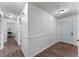 Bright hallway with hardwood floors and white trim, leading to bedrooms and a front entrance at 1021 Mare Bello Dr, Winter Park, FL 32792
