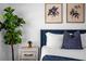 Cozy bedroom showcasing a bedside plant, a tufted headboard with nailhead trim, and decorative botanical art at 1106 Kingsbarn St, Davenport, FL 33896