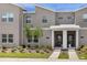 Modern townhouse featuring a stucco exterior with white accents and well-maintained landscaping at 1106 Kingsbarn St, Davenport, FL 33896