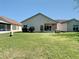 Large green backyard featuring a well-maintained lawn and partial home view at 11624 Peach Grove Ln, Orlando, FL 32821