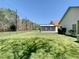 Expansive backyard with lush grass, screened-in lanai, and a secure fence offering privacy and outdoor enjoyment at 11624 Peach Grove Ln, Orlando, FL 32821