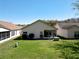 Well-maintained backyard with a screened-in lanai, lush lawn, and mature landscaping, ideal for relaxing and entertaining at 11624 Peach Grove Ln, Orlando, FL 32821