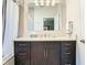 Modern bathroom features a dark vanity cabinet with a white countertop and a large mirror at 11624 Peach Grove Ln, Orlando, FL 32821