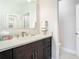 Modern bathroom features a dark vanity cabinet with a white countertop and a large mirror at 11624 Peach Grove Ln, Orlando, FL 32821