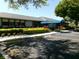 Well-maintained clubhouse featuring lush landscaping, mature trees, a covered entrance and ample parking at 11624 Peach Grove Ln, Orlando, FL 32821
