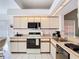 Functional kitchen with tile floor, white appliances, and white cabinets is ready for new owners at 11624 Peach Grove Ln, Orlando, FL 32821
