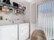 Laundry Room features newer washer and dryer, plus shelving for storage, adjacent to a chair at 11624 Peach Grove Ln, Orlando, FL 32821