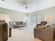 Bright living room featuring neutral walls, plush carpeting, and sliding glass doors to the backyard at 11624 Peach Grove Ln, Orlando, FL 32821