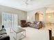 Bright living room with neutral tones, ceiling fan, and sliding glass doors to the outdoor patio at 11624 Peach Grove Ln, Orlando, FL 32821