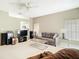 Open-concept living room with carpet, neutral walls, ceiling fan, comfortable seating, and natural light from the windows at 11624 Peach Grove Ln, Orlando, FL 32821