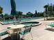 A relaxing community pool and jacuzzi area is complete with lounge chairs and shady umbrellas at 11624 Peach Grove Ln, Orlando, FL 32821
