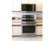 Stainless steel stove and microwave combination are surrounded by white cabinets and beige countertop at 11624 Peach Grove Ln, Orlando, FL 32821