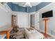 Bedroom featuring a tray ceiling, wood floors, desk and a comfortable ottoman at 124 Windsor Cresent St, Winter Springs, FL 32708