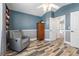 Bedroom with wood floors leading to an ensuite bathroom and a gray armchair at 124 Windsor Cresent St, Winter Springs, FL 32708