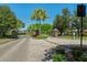 Gated community entrance featuring brick columns, mature landscaping, and a paved brick road at 124 Windsor Cresent St, Winter Springs, FL 32708