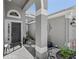 Inviting entryway with decorative plants, black front door, gray walls, and stone accents at 124 Windsor Cresent St, Winter Springs, FL 32708