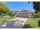 Beautiful one-story home showcases an attached two-car garage, manicured lawn, and gray exterior at 124 Windsor Cresent St, Winter Springs, FL 32708