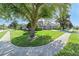 Well-manicured front yard of a gray home with a two-car garage, green lawn, and sidewalk at 124 Windsor Cresent St, Winter Springs, FL 32708