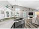 Kitchen sink area with stainless steel farmhouse sink and a view into the living area at 124 Windsor Cresent St, Winter Springs, FL 32708