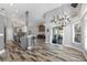 Open-concept living space with gray walls and wood-look floors, leading to kitchen and dining area at 124 Windsor Cresent St, Winter Springs, FL 32708