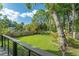 Lush, green backyard showcasing a spacious lawn, mature trees, and a charming pergola, creating a serene outdoor oasis at 1407 E Kaley St, Orlando, FL 32806