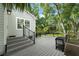 Backyard view of home and deck with wooden stairs and black metal railings at 1407 E Kaley St, Orlando, FL 32806