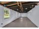 View of open basement with exposed rafters, painted walls, concrete floor, and backyard access at 1407 E Kaley St, Orlando, FL 32806