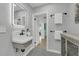 Bathroom with a console sink, gray hexagon tile flooring, and an open doorway revealing the home's interior at 1407 E Kaley St, Orlando, FL 32806