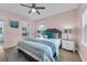 Comfortable bedroom featuring hardwood floors, ceiling fan, pastel walls, a bed, and windows for natural light at 1407 E Kaley St, Orlando, FL 32806