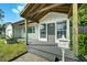 Close up of the home's covered front porch, entry door, mailbox, and a partial view of the yard at 1407 E Kaley St, Orlando, FL 32806