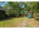 Spacious backyard featuring mature trees, a lush lawn, and a wooden playset with a green slide at 1432 W Yale St, Orlando, FL 32804