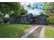 Charming single-story home features dark siding, manicured lawn, and a brick driveway, exuding curb appeal at 1432 W Yale St, Orlando, FL 32804