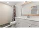 Modern bathroom with pebble-stone shower floor, white vanity, and framed mirror at 1505 Guinevere Dr, Casselberry, FL 32707