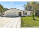 Charming single-story home with a well-maintained lawn, attached garage and inviting walkway at 1505 Guinevere Dr, Casselberry, FL 32707