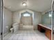 Well-lit bathroom featuring a soaking tub, tiled walls, and double sinks at 1509 Jason St, Kissimmee, FL 34744