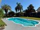 Backyard swimming pool surrounded by lush landscaping and green lawn at 1509 Jason St, Kissimmee, FL 34744