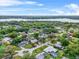 Wide aerial view of homes surrounded by lush trees with a lake in the distance at 1610 Stephanie Ln, Lakeland, FL 33813