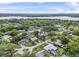 Neighborhood view of a single Gathering home with lush green trees and a lake in the distance at 1610 Stephanie Ln, Lakeland, FL 33813