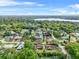 Aerial view of homes with pools surrounded by lush green trees and a lake at 1610 Stephanie Ln, Lakeland, FL 33813