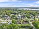 Aerial view of homes with pools surrounded by lush green trees and a lake at 1610 Stephanie Ln, Lakeland, FL 33813